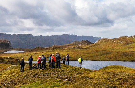 LECTURE-HOSTED-OUTING_436x285 Group of hikers looking at lake with mountains in background