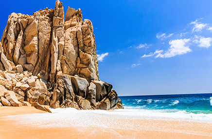 rock structure touching beach and ocean