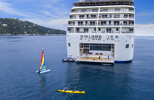 seas People doing kayak and wind sail around back of cruise ship