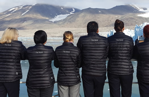 th8 group of people looking at mountains on deck of ship